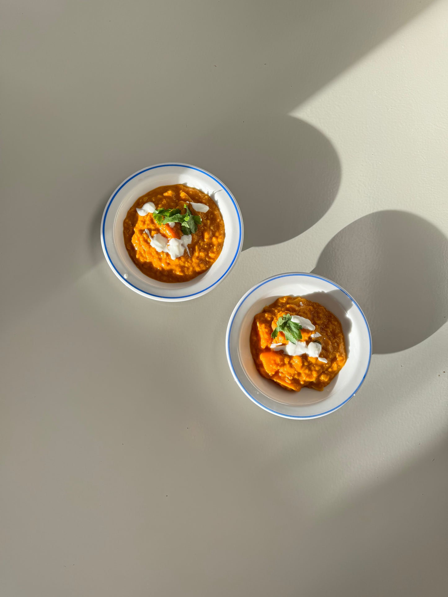 Two bowls of Kabocha Lentil Stew on a light background, one bowl is in the foreground and the other in the background.