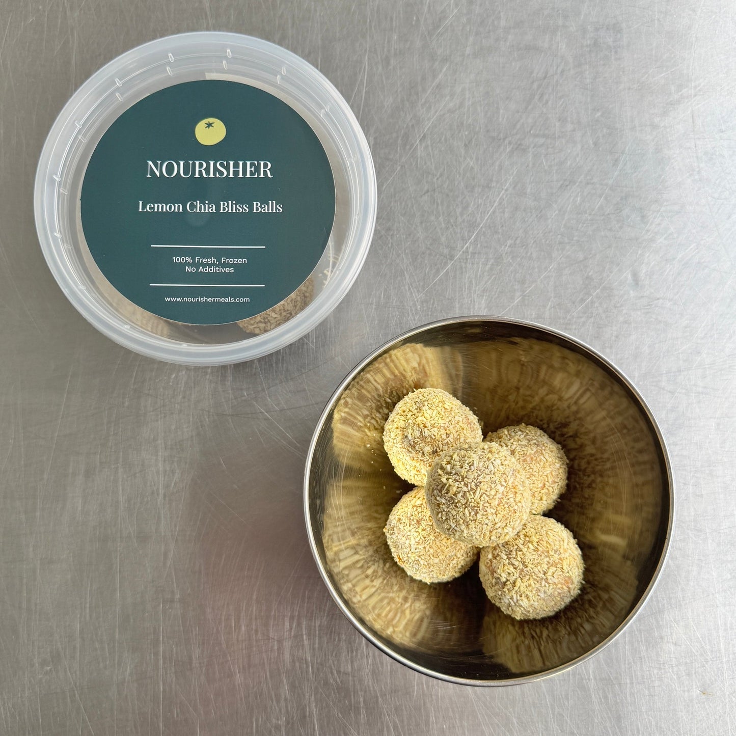 Container of lemon thyme tea balls on a metallic surface