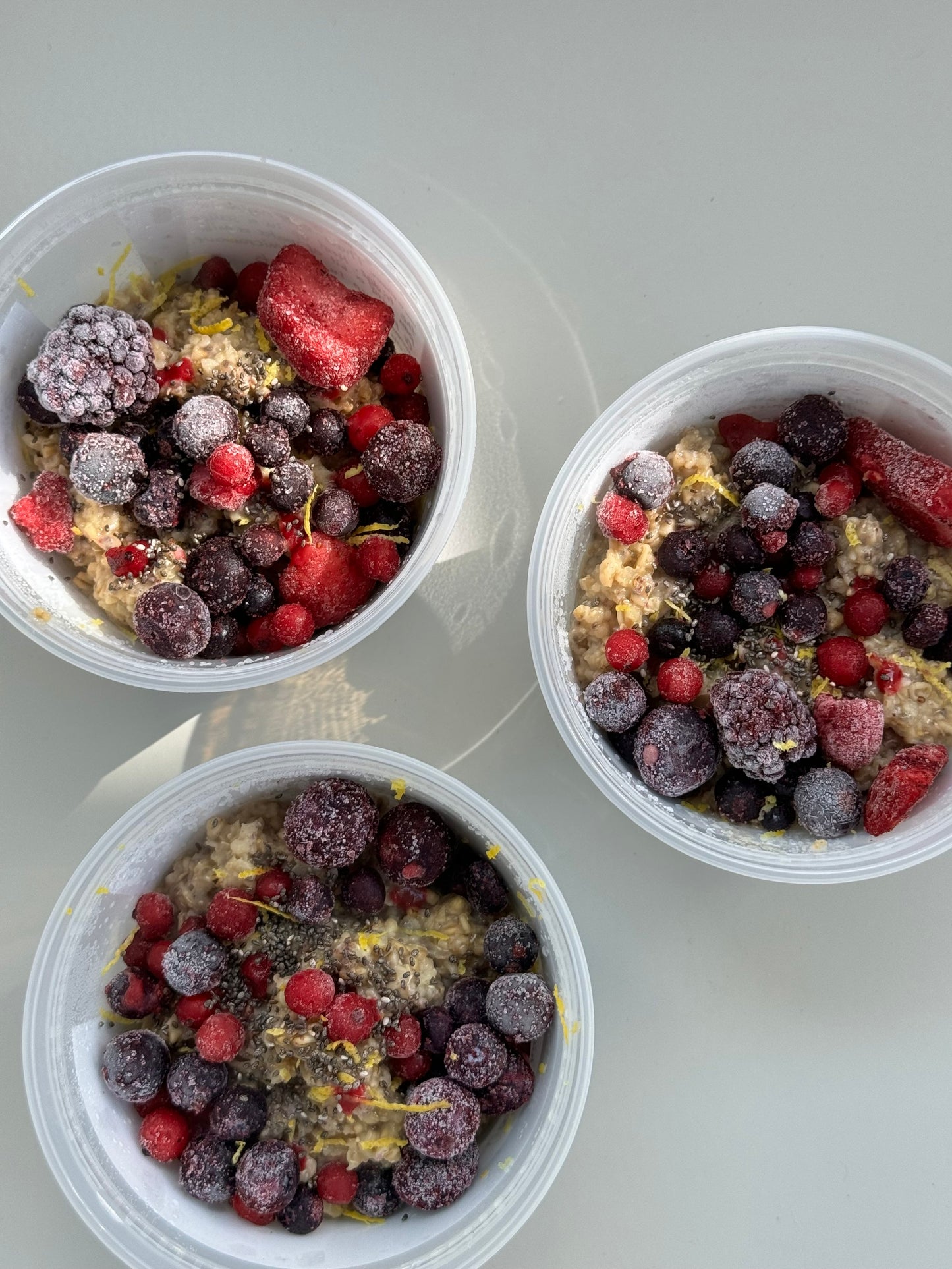 A Portion Oats Chia Apples in a Bowl surrounded by shade with red fruits