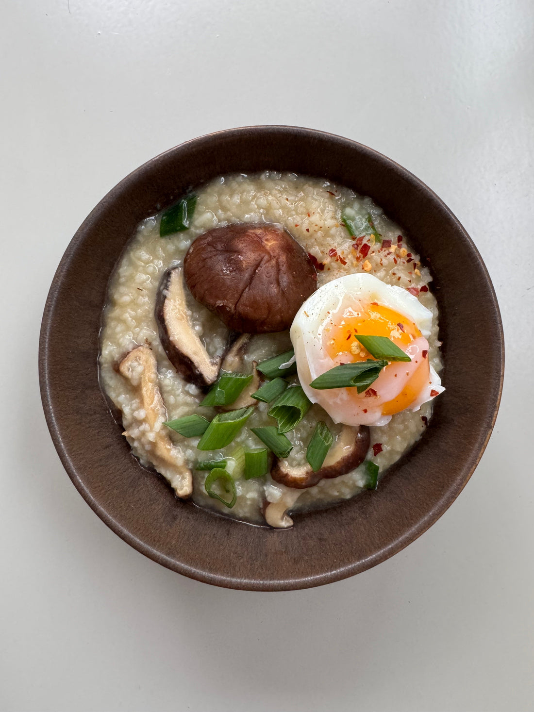 Hot bowl of nourishing postpartum porridge with Shiitake Mushrooms and Eggs