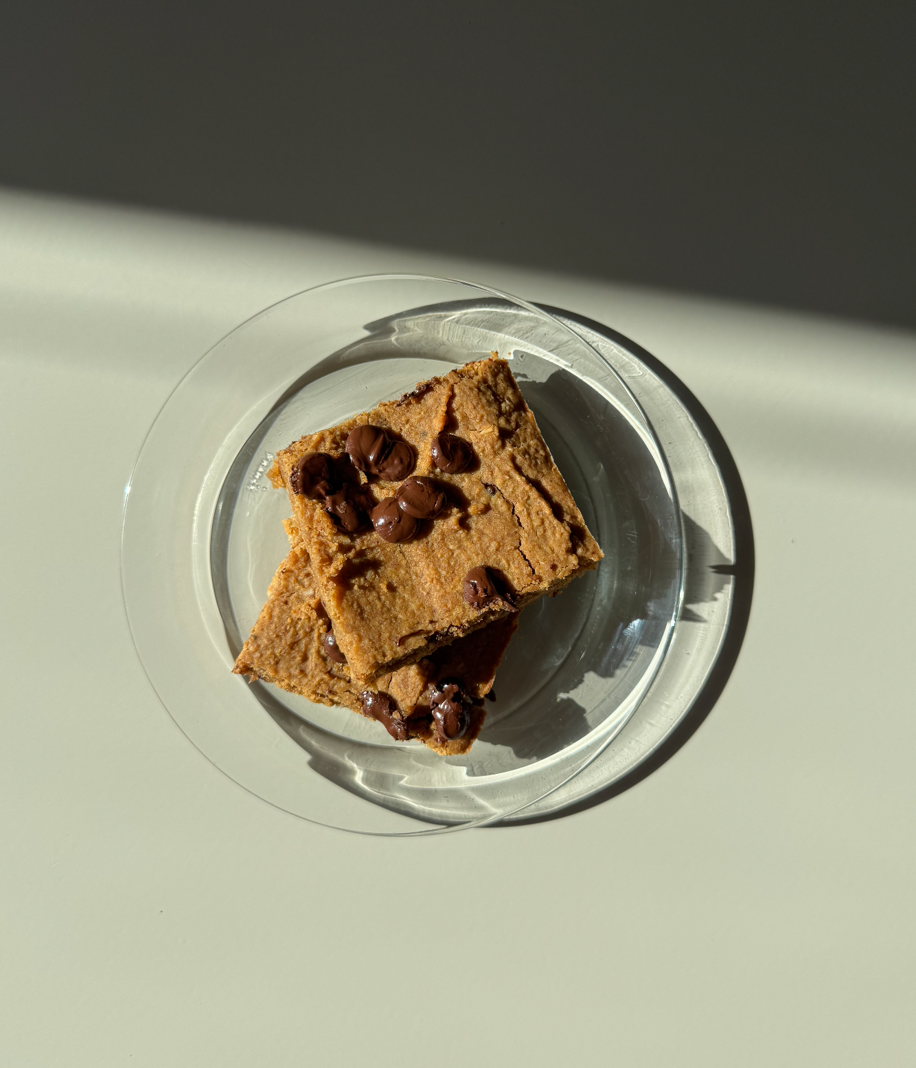 A plate with several peanut butter chocolate chip blondies, naturally sweetened treats.