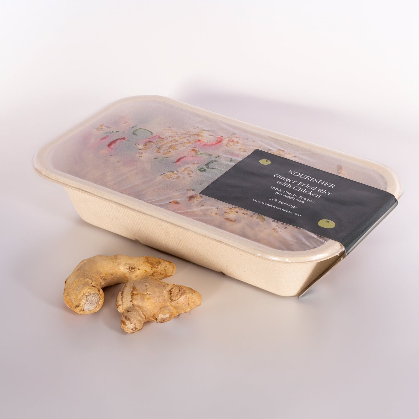 Packaged ginger fried rice with chicken and ginger laying in front of it.