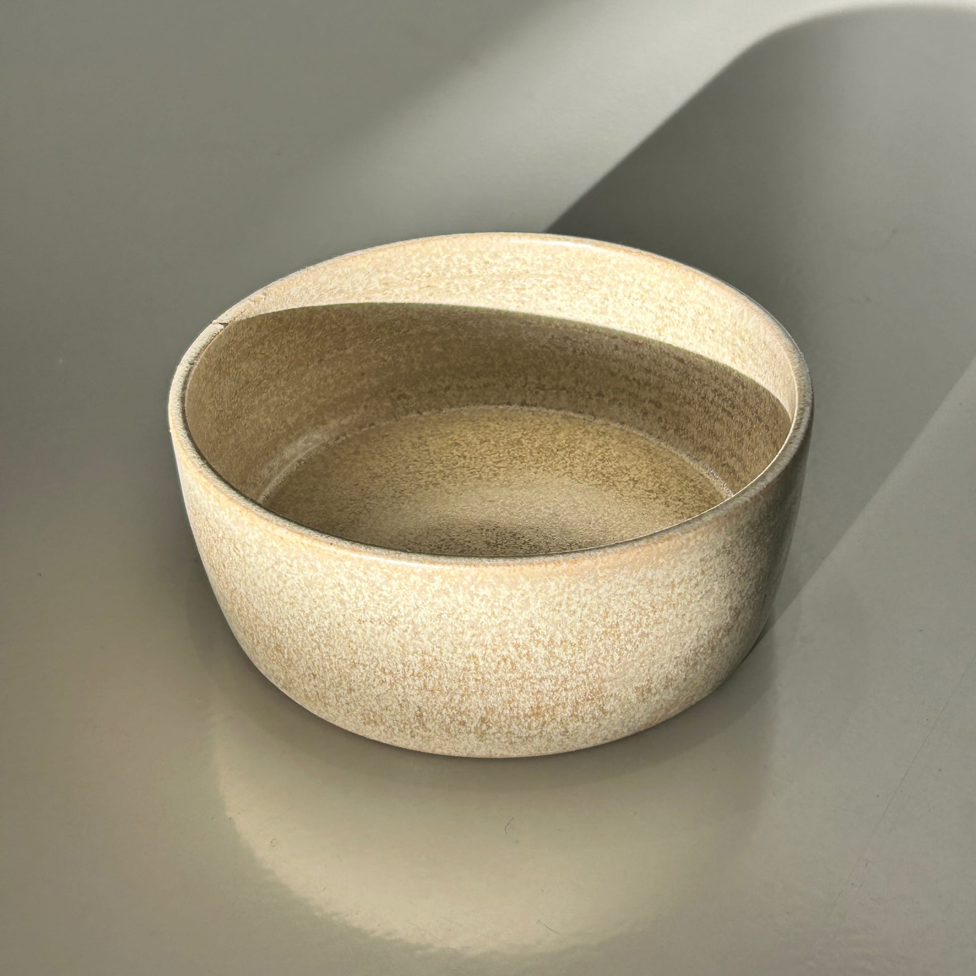Beige ceramic bowl on a gray background